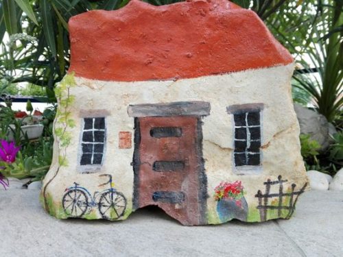 painted rock fairy house with bike
